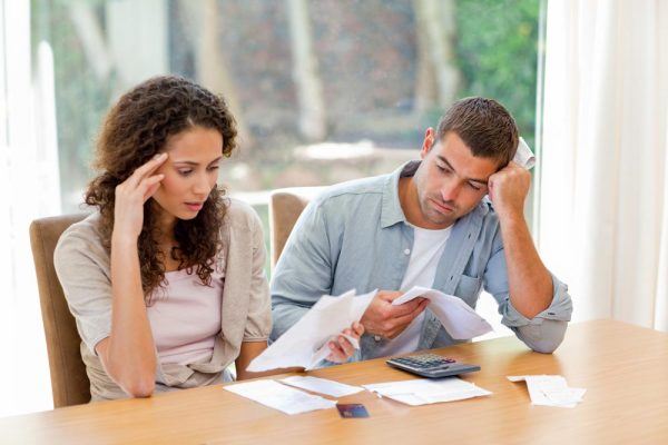 couple stressed by bills and receipts